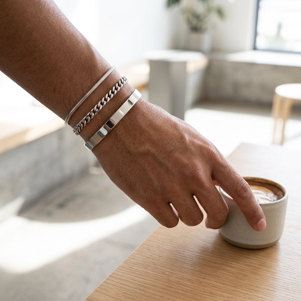 Silver bracelets on wrist reaching for coffee